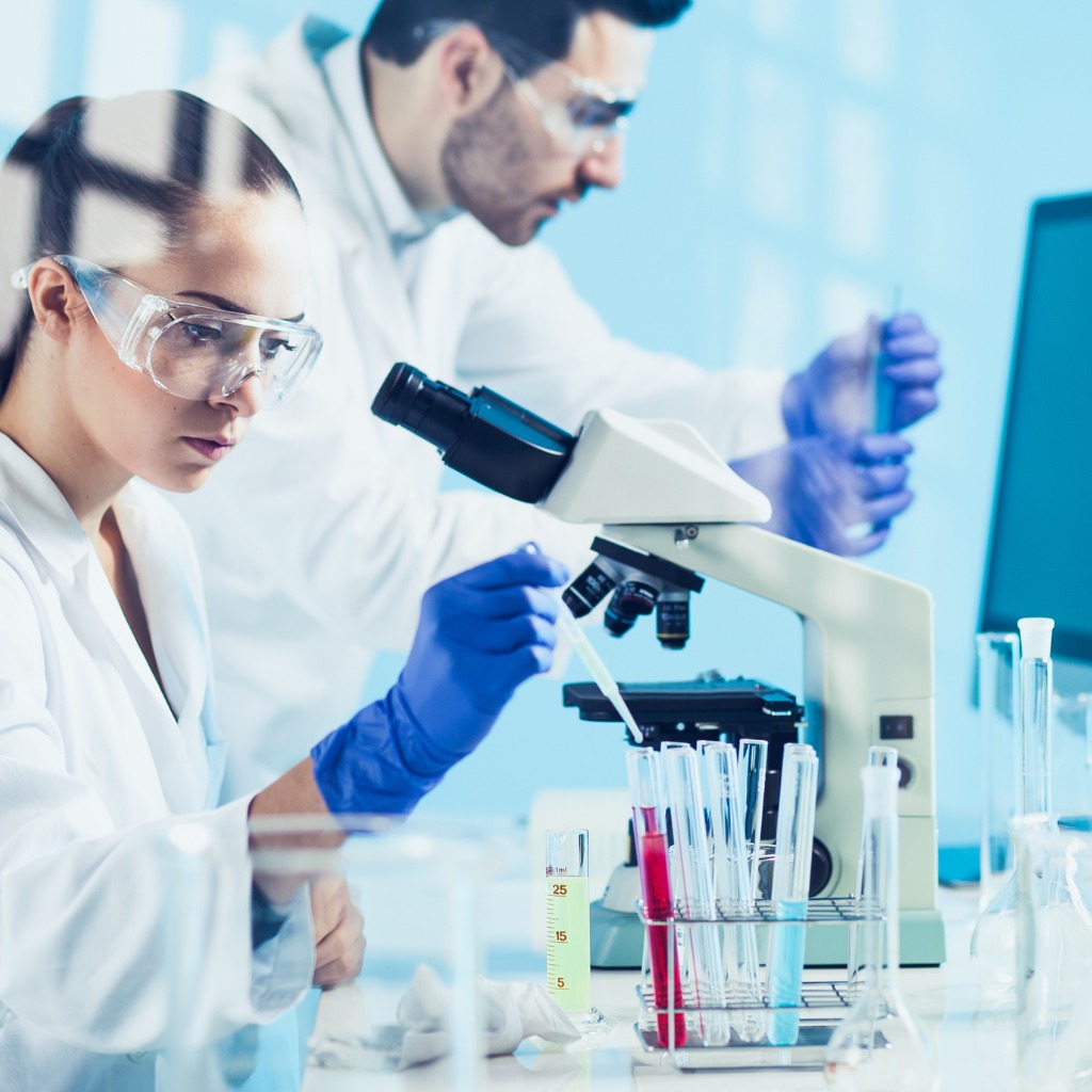 Scientists analyzing samples under a microscope in a laboratory.